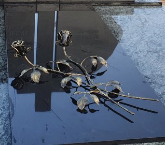 Dvi sukryžiuotos rožės ant kapo